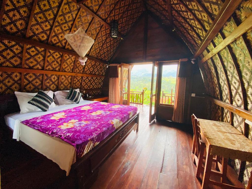 1 dormitorio con 1 cama en una cabaña de madera en Villa Lumbung Ayu Sari & Spa, en Karangasem