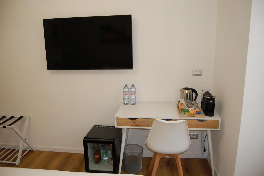 a desk with a chair and a television on a wall at Belltower Elegans in Rome