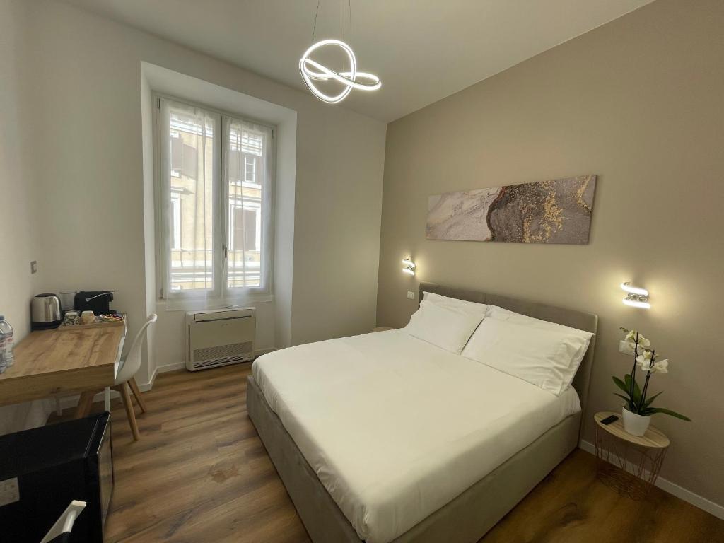 a bedroom with a bed and a desk and a window at Belltower Elegans in Rome
