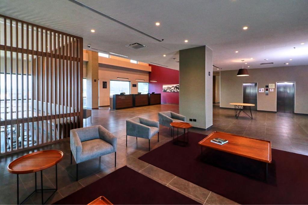 a lobby with chairs and a table in a building at City Express by Marriott Monterrey Universidad in Monterrey