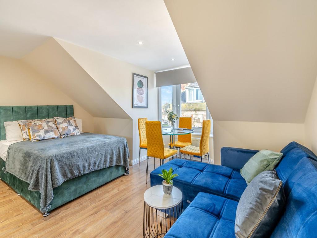 een slaapkamer met een bed en een blauwe bank bij Apartment Six - Uk44288 in Arbroath