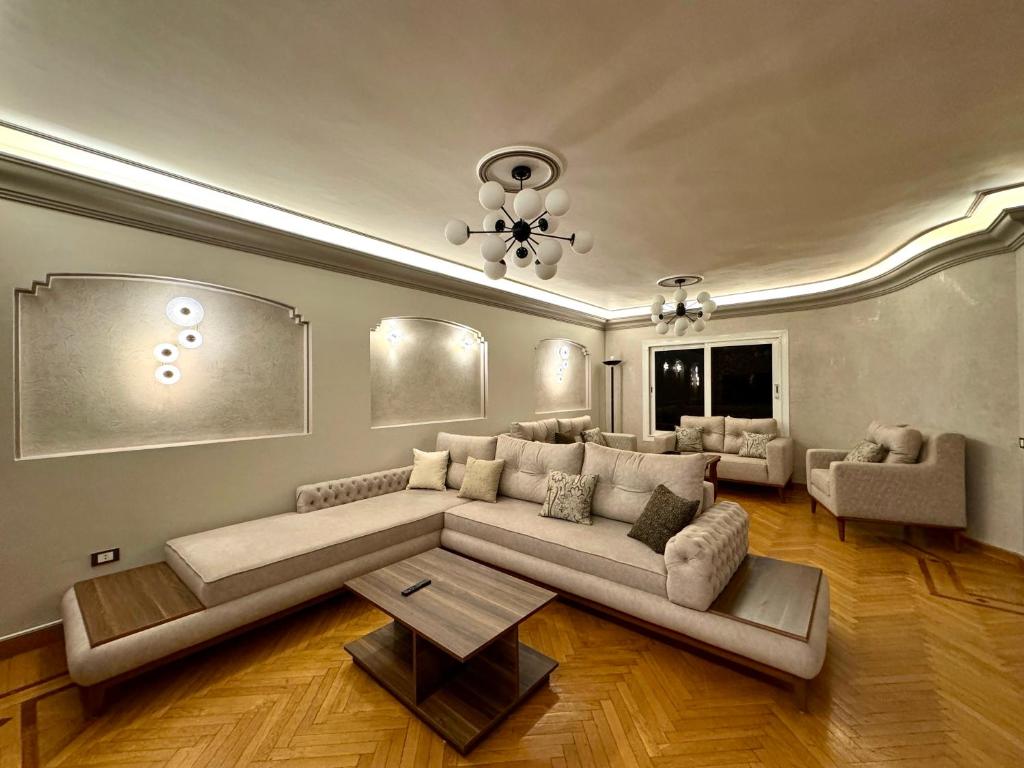 uma sala de estar com um sofá grande e uma mesa em Elegant Apartment no Cairo