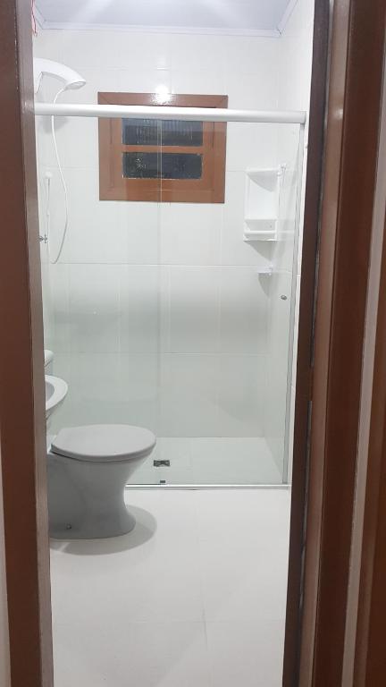 een badkamer met een toilet en een glazen deur bij Casa da Mari in Canela