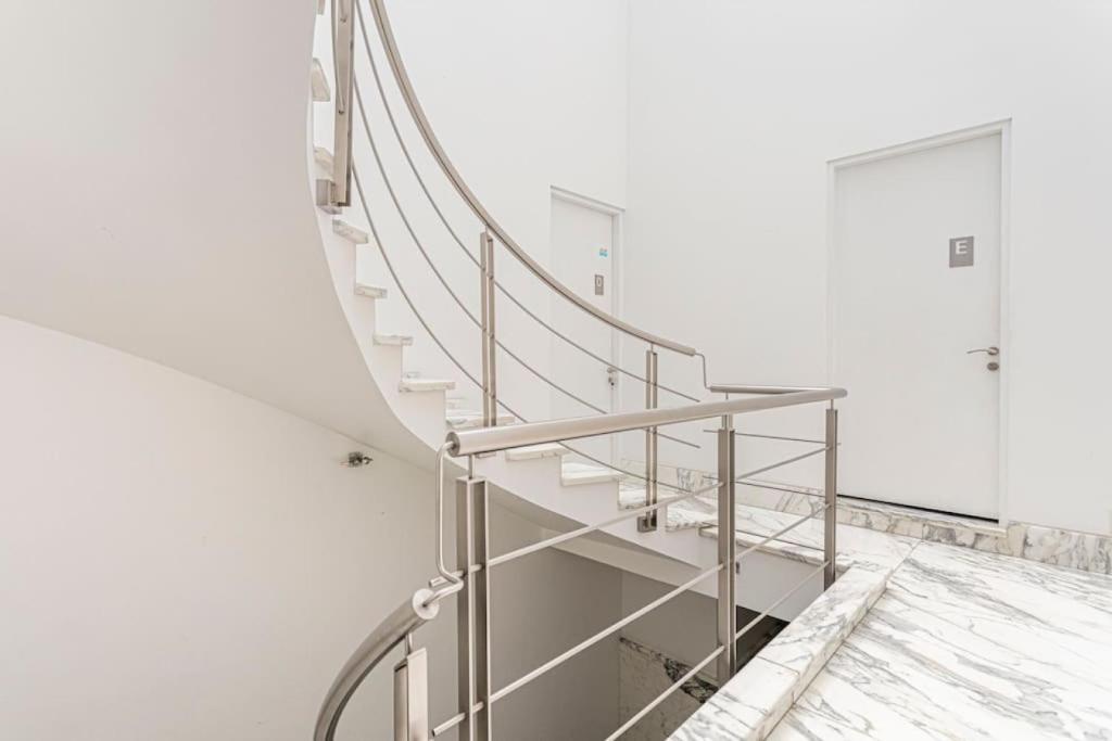a metal spiral staircase in a white room at Condesa Residence Amsterdam E Cozy Living Space in the Heart of the City on Amsterdam Avenue in Mexico City