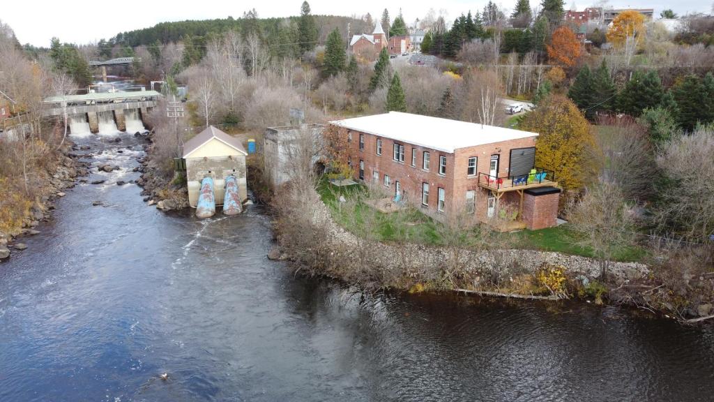 an aerial view of a building next to a river at Burk's Fall Modern Mill House Apt 3 in Burks Falls
