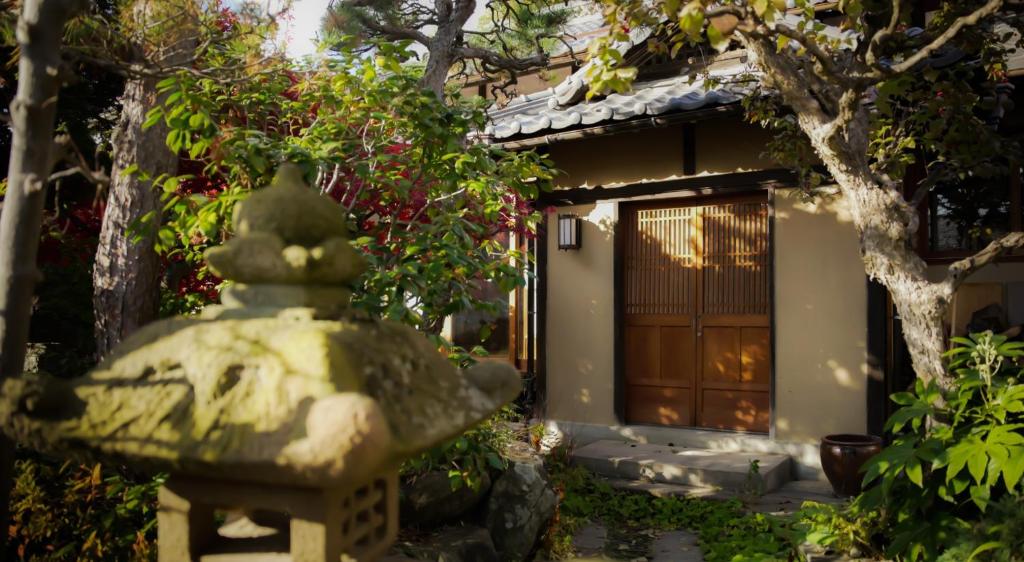 uma fonte de pedra em frente a uma casa em Maison d'hôtes KIRISIMIZU - Vacation STAY 40997v em Nagano