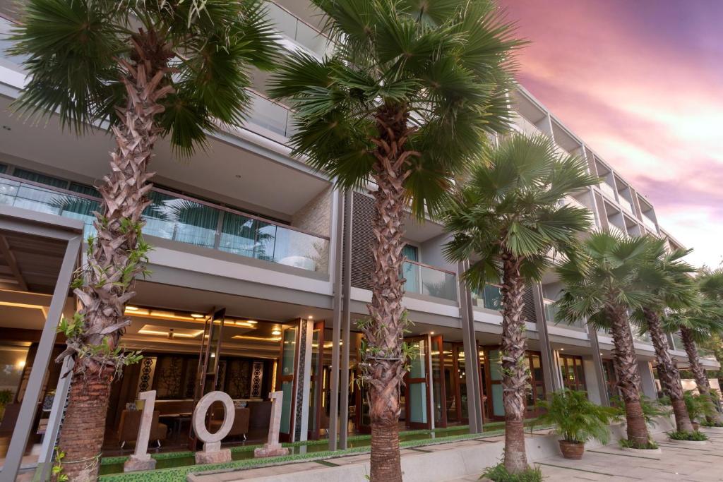 a group of palm trees in front of a building at The Regent Phuket Bangtao Beach in Bang Tao Beach