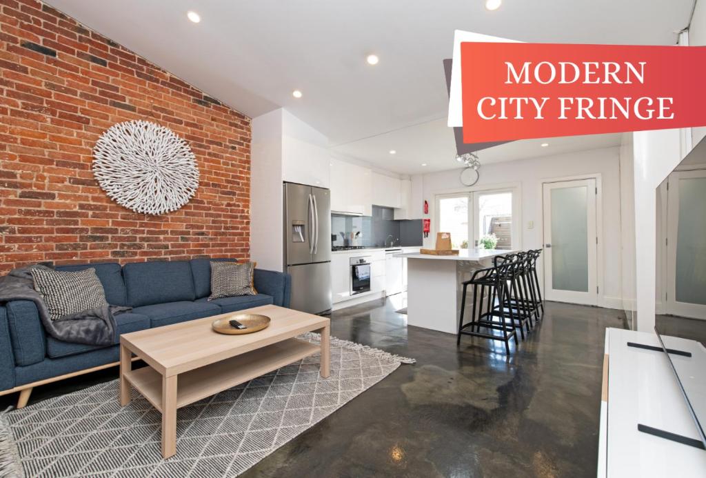 a living room with a blue couch and a brick wall at Character filled cottage in Norwood - Free wine in Adelaide