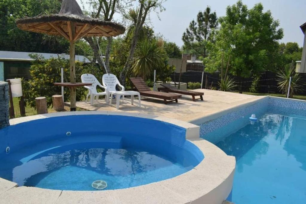 a blue pool with chairs and an umbrella at Altavista TERRA in Colón