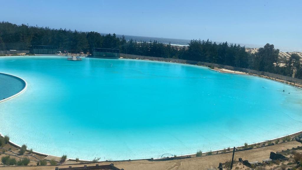 a large pool of blue water with trees around it at Lagunamar las cruces in El Tabo