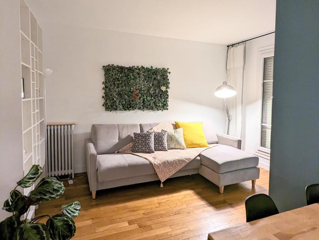 a living room with a couch with pillows on it at Cosy little nest next to Paris in Issy-les-Moulineaux