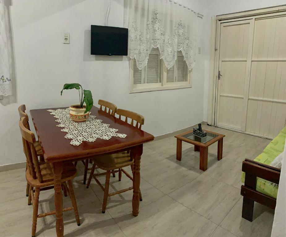a dining room table and chairs in a living room at Casa cinza in São Lourenço do Sul