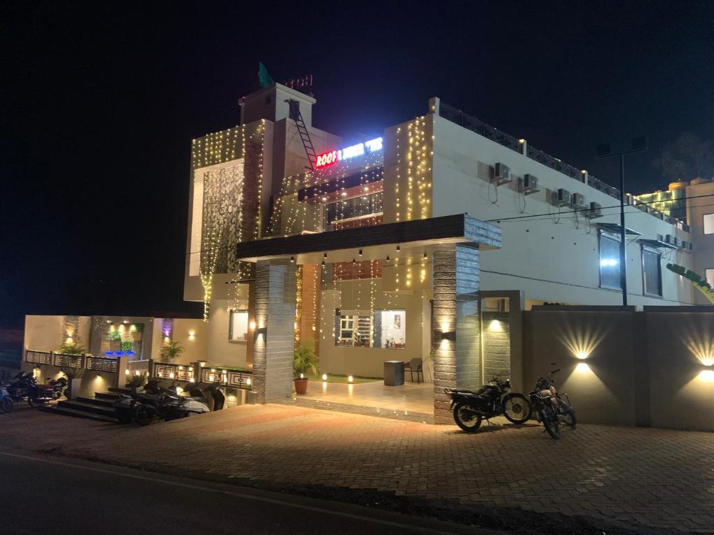 um edifício com motocicletas estacionadas em frente a ele à noite em Hotel Saluja Primeland em Parāsia
