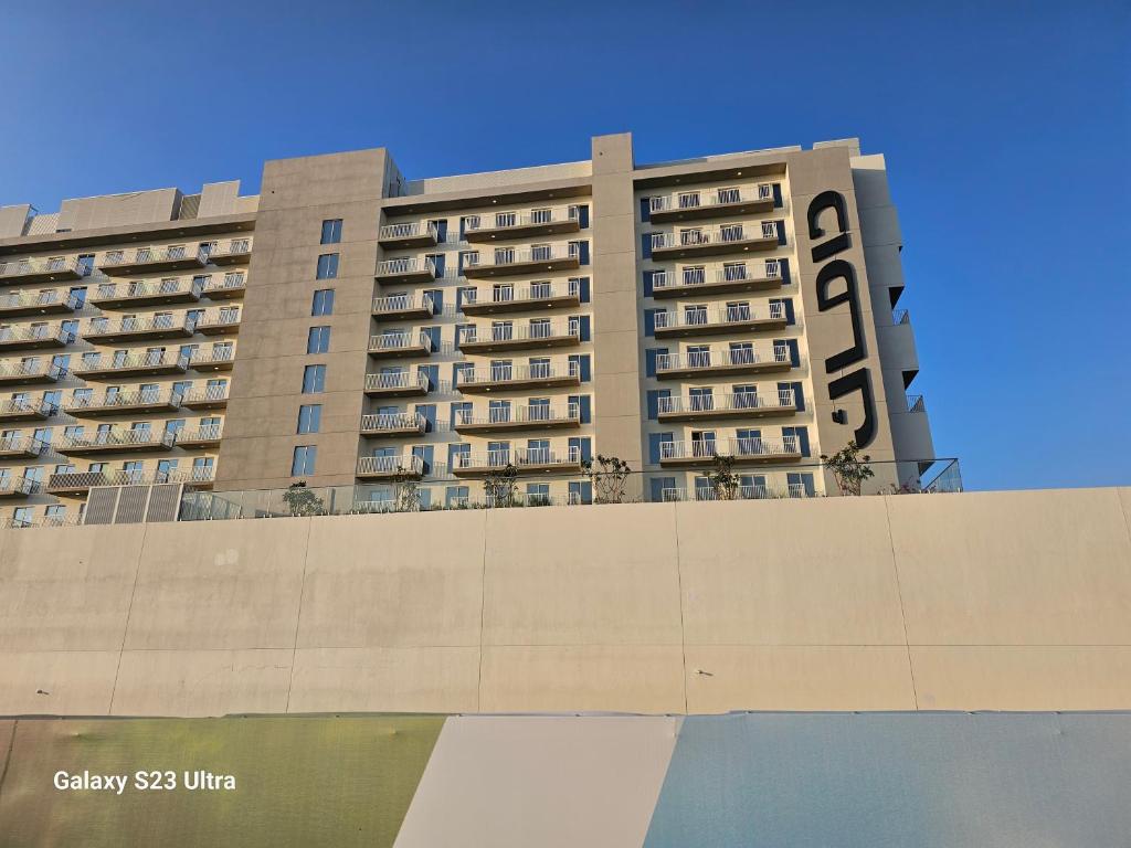 un grand immeuble avec un ciel bleu en arrière-plan dans l'établissement Ensuite one bedroom in a 2-bedroom with a shared living room, à Dubaï