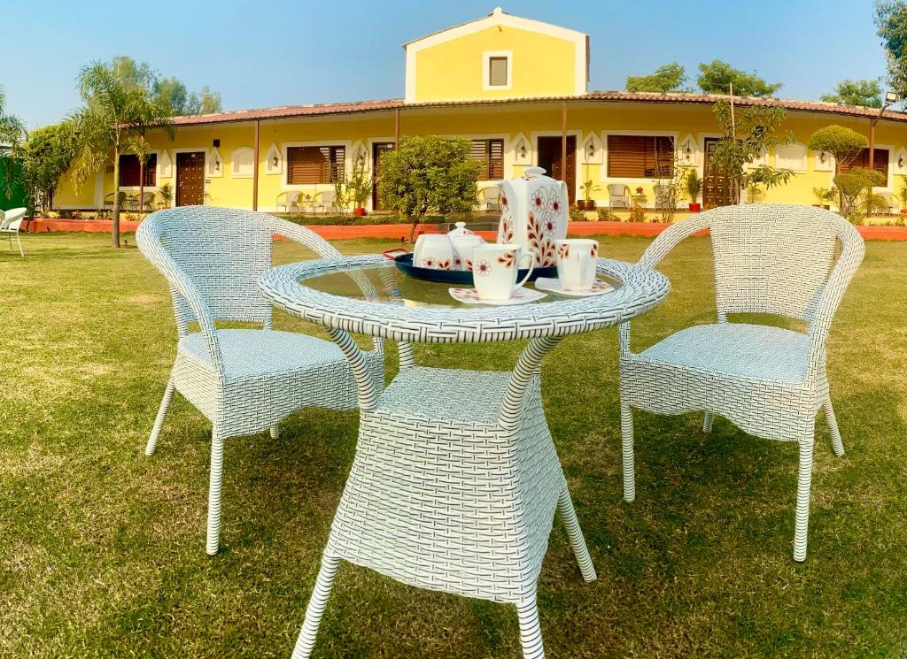 a table with four chairs and a tea set on it at Vanzara Retreat in Gurgaon
