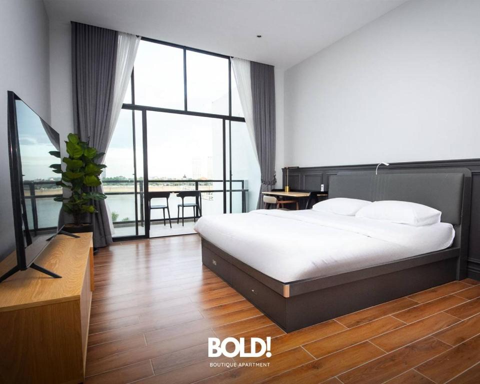 a bedroom with a bed and a large window at BOLD! apartment @ Riverside in Phnom Penh