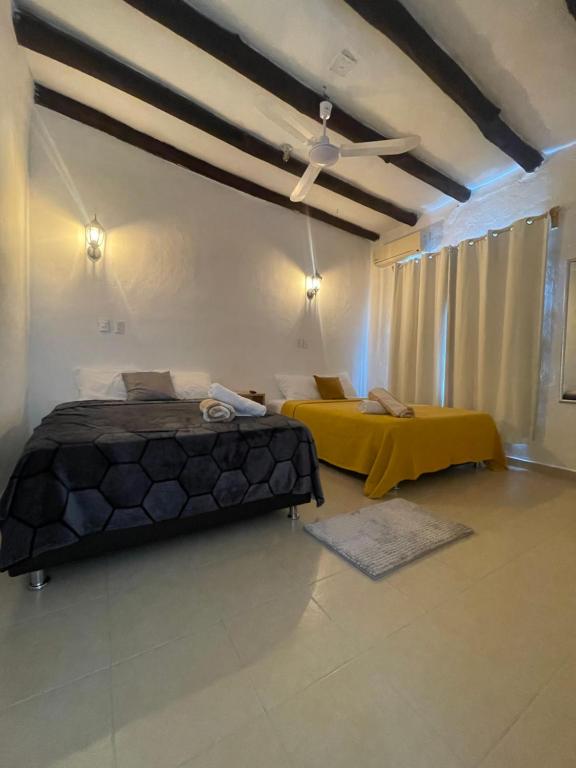 a bedroom with two beds and a yellow table at Casa Blue "HABITACION DELFIN" in Holbox Island