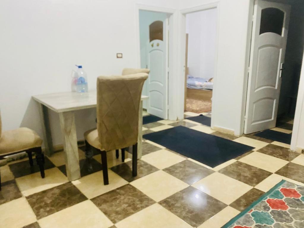comedor con mesa y sillas y suelo a cuadros en شقة فندقية بالزقازيق en Zaqazîq