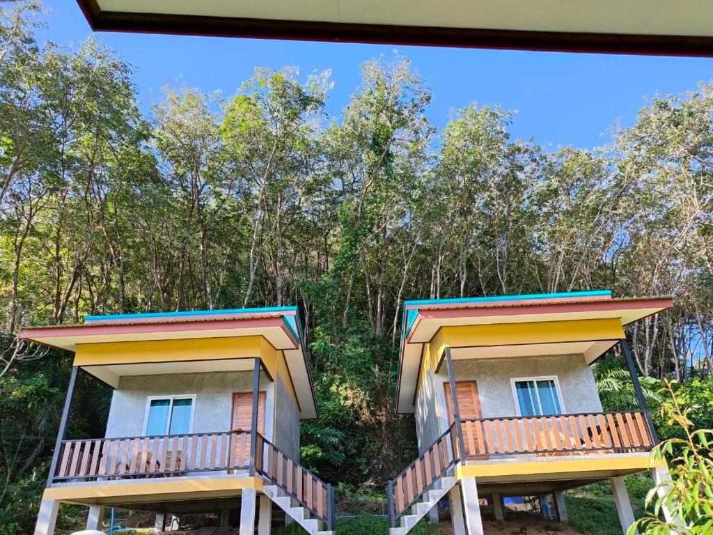 a building with two balconies with trees in the background at Baanchomjan Kohyaoyai in Ban Nai Wat