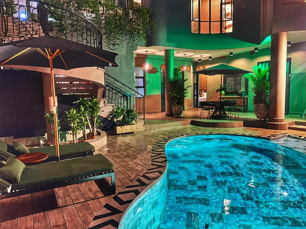 a swimming pool in a hotel with an umbrella at Hotel Osvé Boutique Cali in Cali