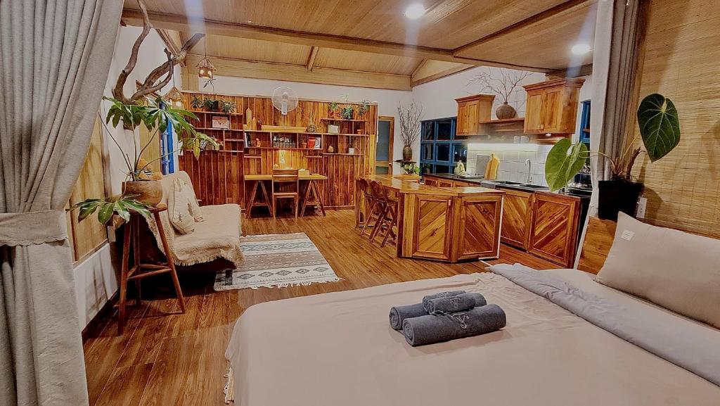 a living room with a bed and a kitchen at TỊNH Retreat Phu Quoc in Phú Quốc