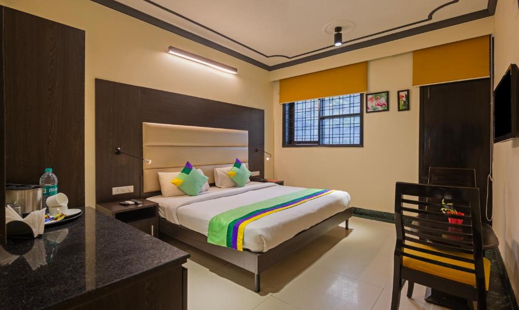 a bedroom with a bed and a desk in a room at Treebo Trend Nv in Gurgaon