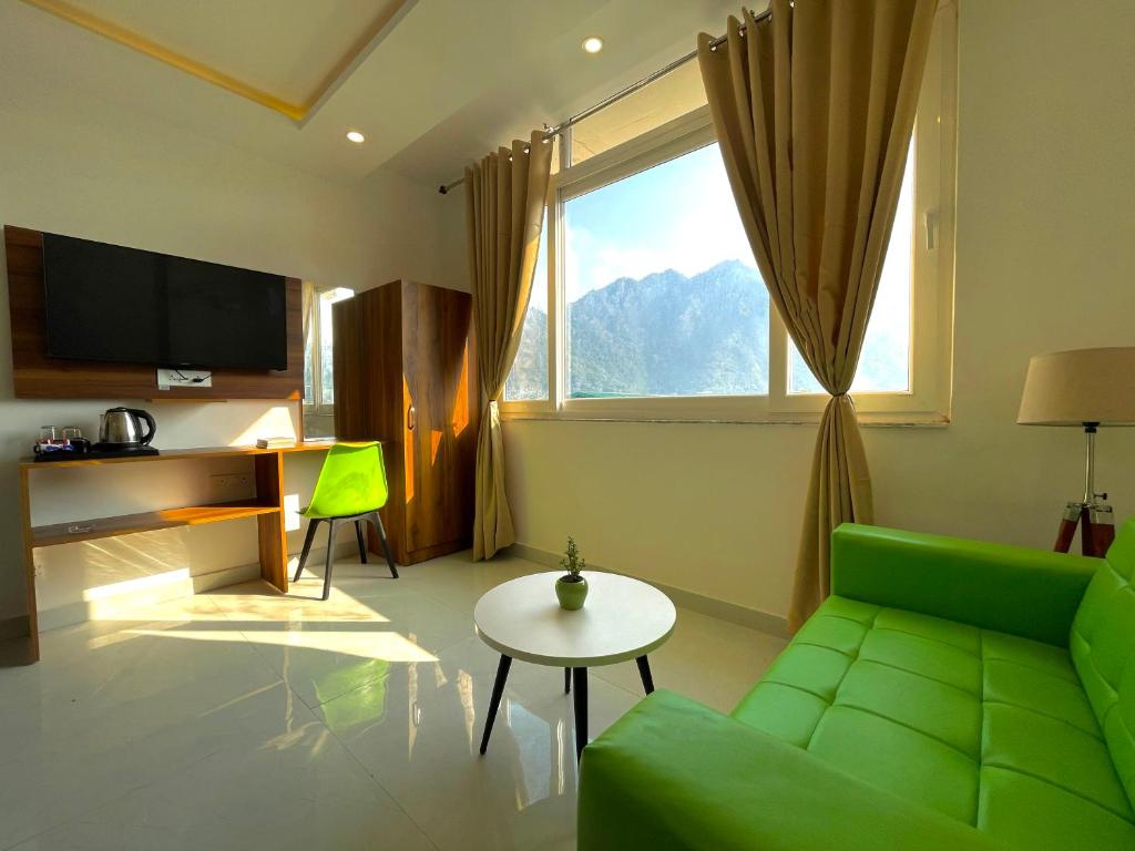 een woonkamer met een groene bank en een raam bij Wanna Stay Rishikesh in Rishīkesh