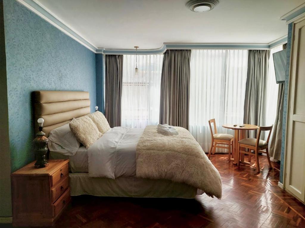 um quarto com uma cama, uma mesa e cadeiras em San Miguel Arcángel em La Paz