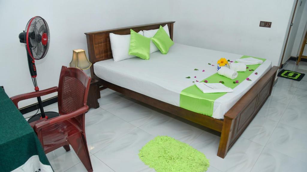 Prem Nadee Hotel في دامبولا: غرفة نوم بسرير كبير وكرسي