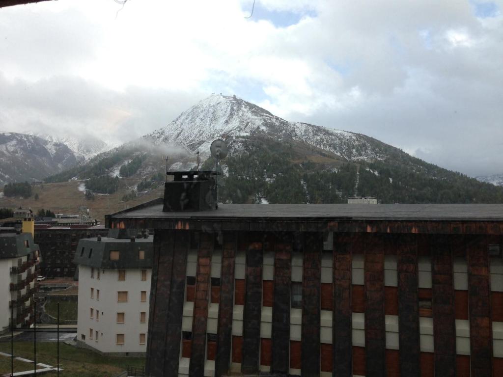 a snow covered mountain in front of a building at SUD OVEST in Sestriere