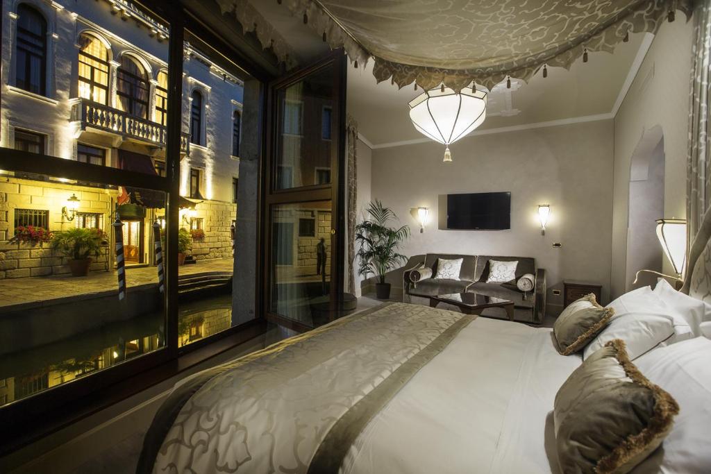 
a hotel room with a large bed and a large window at Ai Mori d'Oriente in Venice
