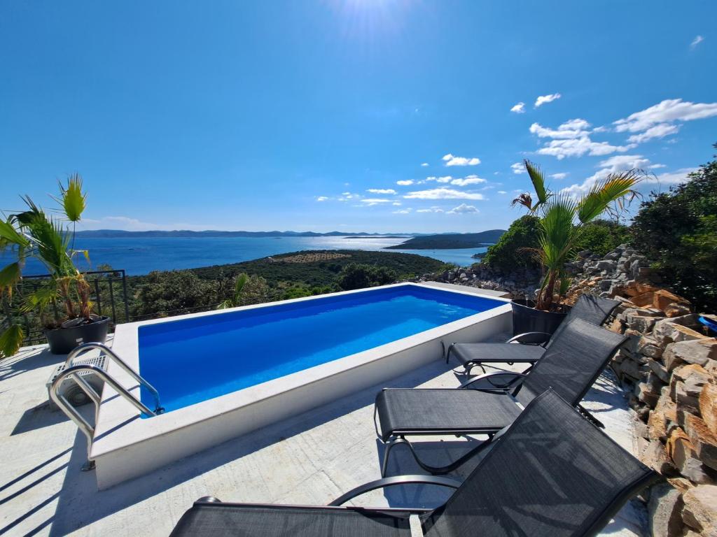 a villa with a swimming pool and chairs on a patio at Villa Robinson in Tkon
