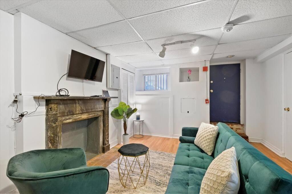 a living room with a green couch and a fireplace at Lovely 1 Bdrm Unit In Center City! in Philadelphia