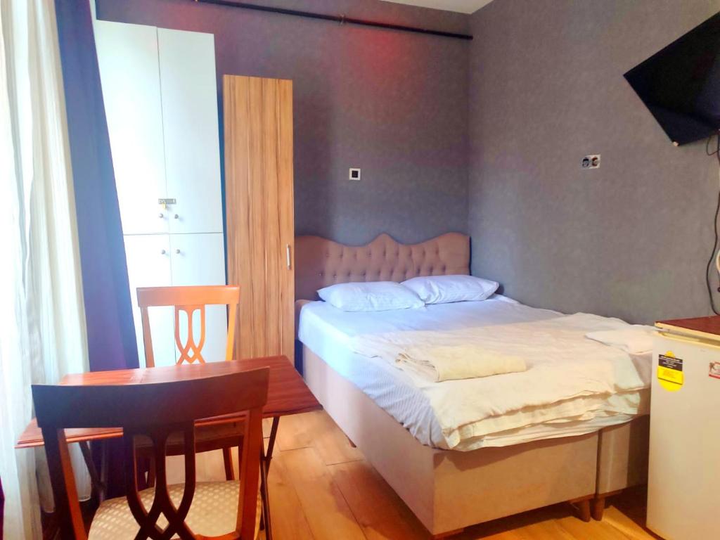 a bedroom with a bed and a table and a tableablish at Family Hotel Taksim in Istanbul