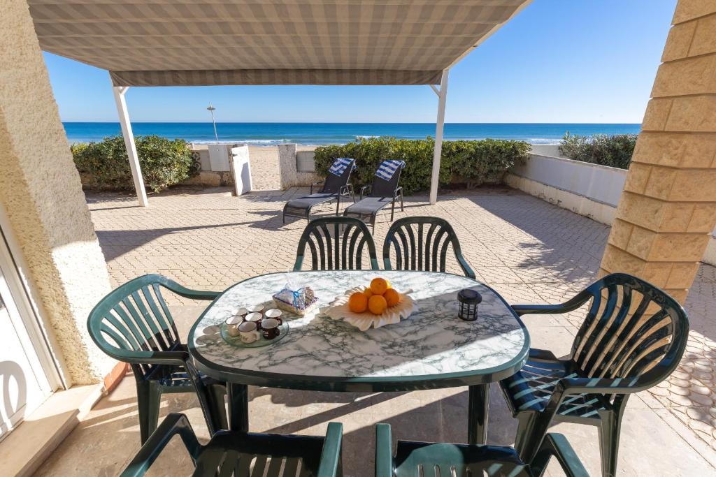 a table and chairs on a patio with the beach at Fidalsa Pacific Beach in Guardamar del Segura