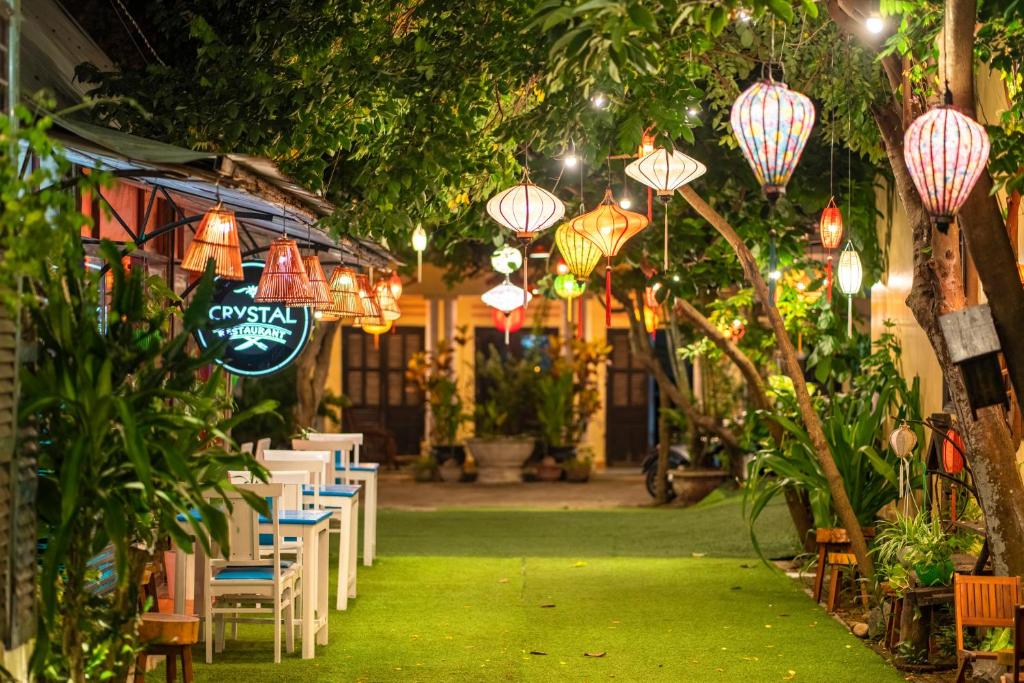 un restaurante con mesas, sillas y luces chinas en Loc Phat Hoi An Homestay, en Hoi An