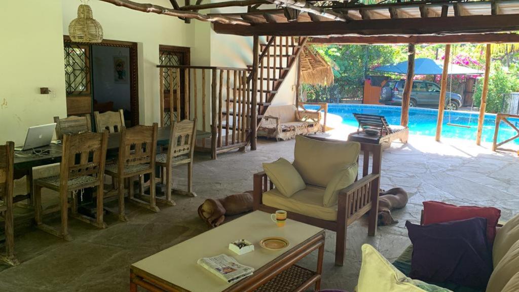 sala de estar con sillas, mesa y piscina en Villascape Malindi Entire Villa en Malindi