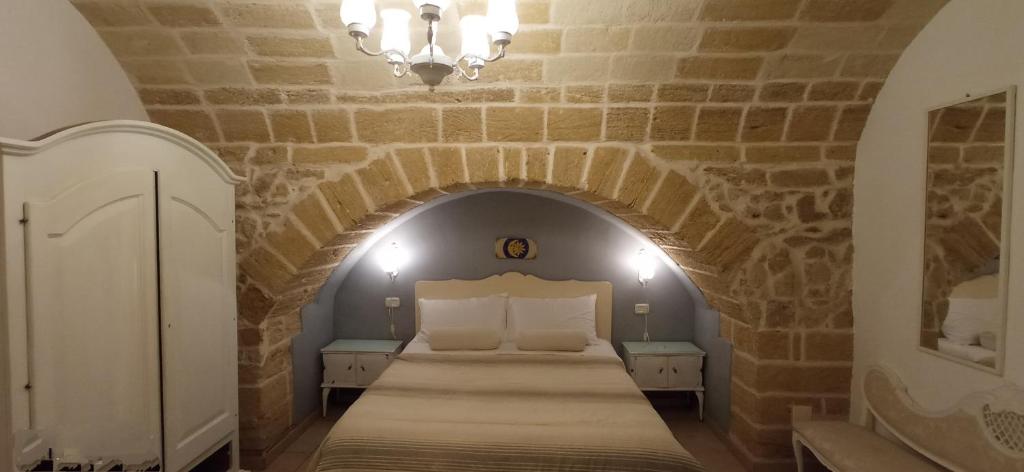 una camera con un letto in un muro di mattoni di Palazzo Saraceno apartments-Antica mangiatoia a Taranto