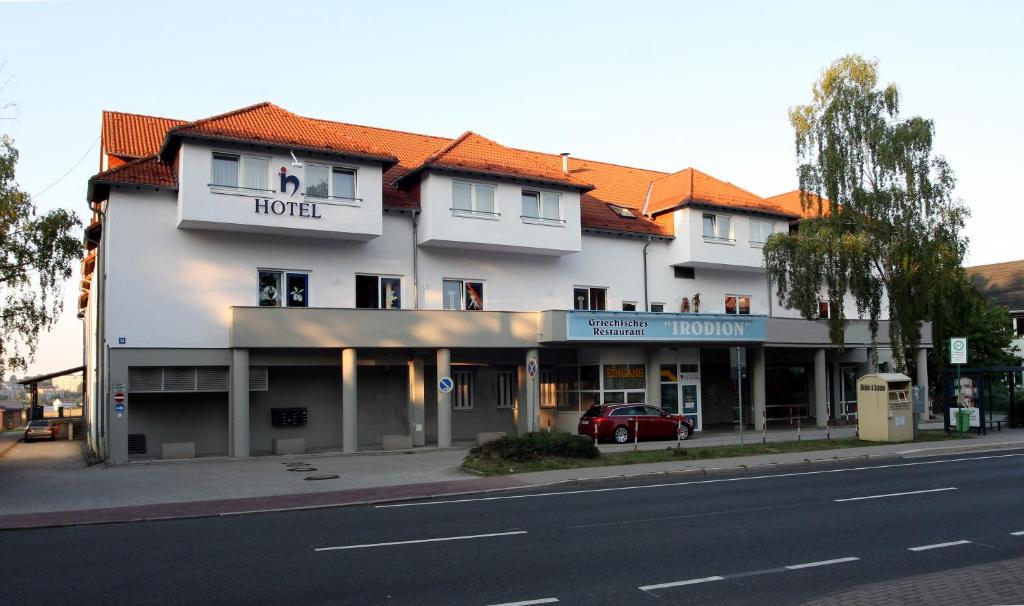 un grand bâtiment blanc avec un hôtel dans une rue dans l'établissement Ilmenauer Hof, à Ilmenau