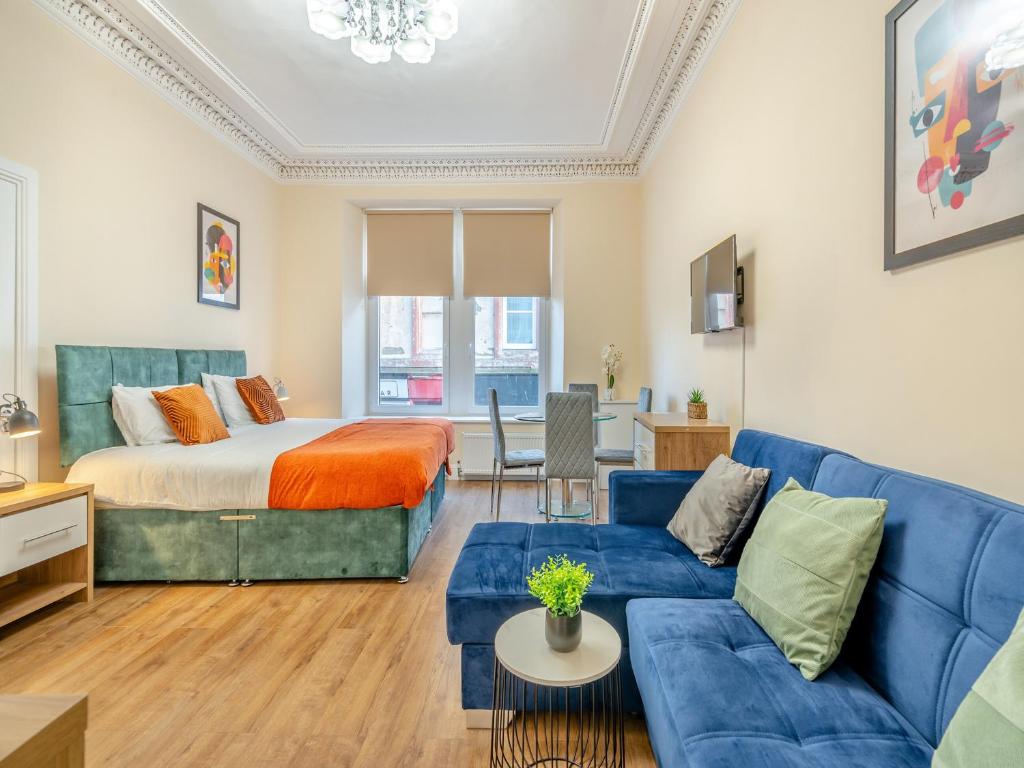 a living room with a bed and a blue couch at Apartment Two - Uk44285 in Arbroath
