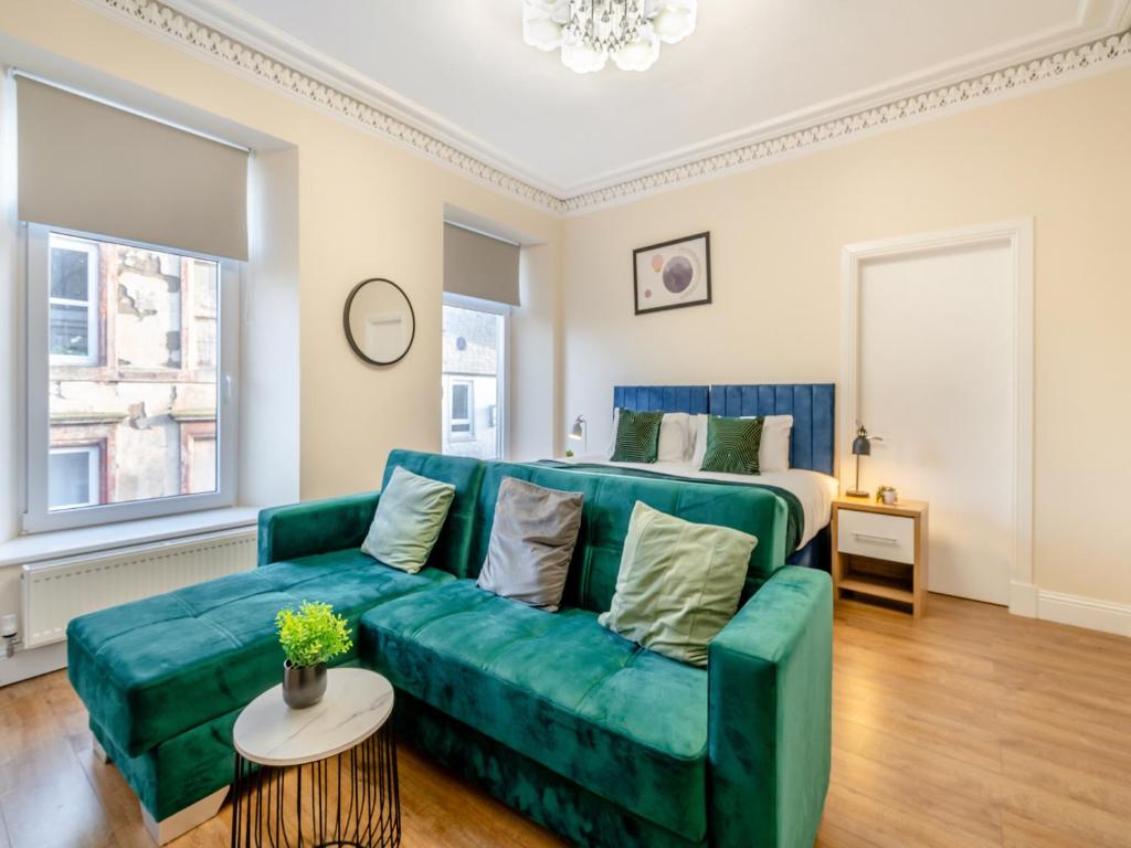 a living room with a green couch and a bed at Apartment Three - Uk44286 in Arbroath