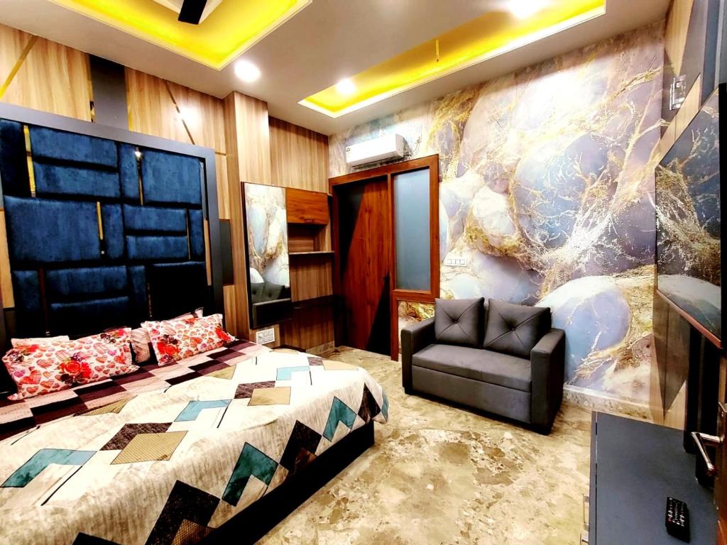范兰德凡Premium Homestay Near Banke Bihari Ji with Power Backup - Free WiFi - Washing Machine etc的一间卧室，里面有一张床、一张沙发和一把椅子