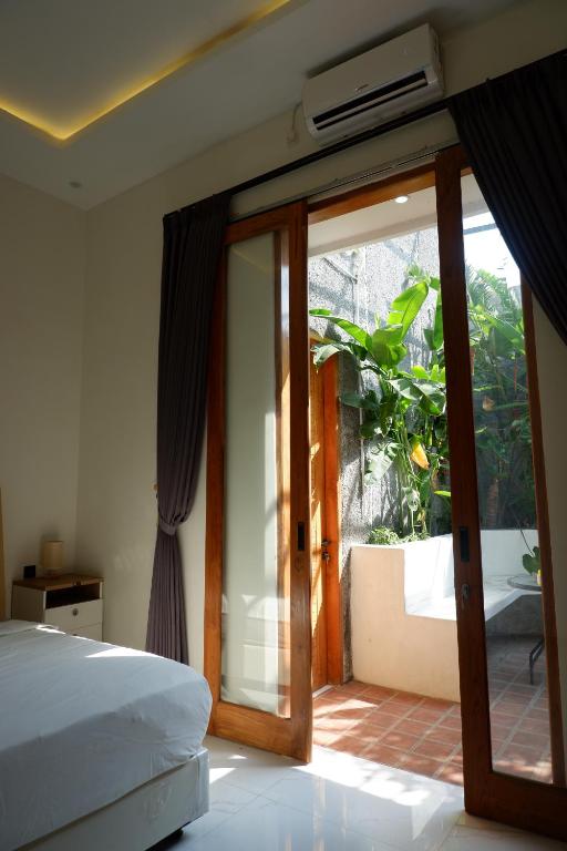 een slaapkamer met een bed en een glazen schuifdeur bij Bromo Venture in Probolinggo