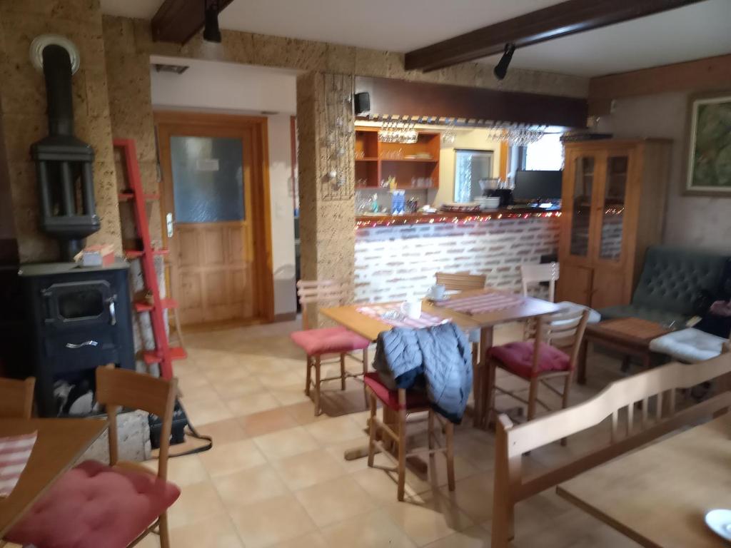 a room with a table and chairs and a stove at Apartmani - Mesko vajat in Divčibare