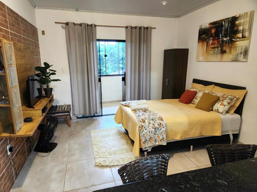 um quarto com uma cama e uma televisão num quarto em Aconchego Standart em Angra dos Reis