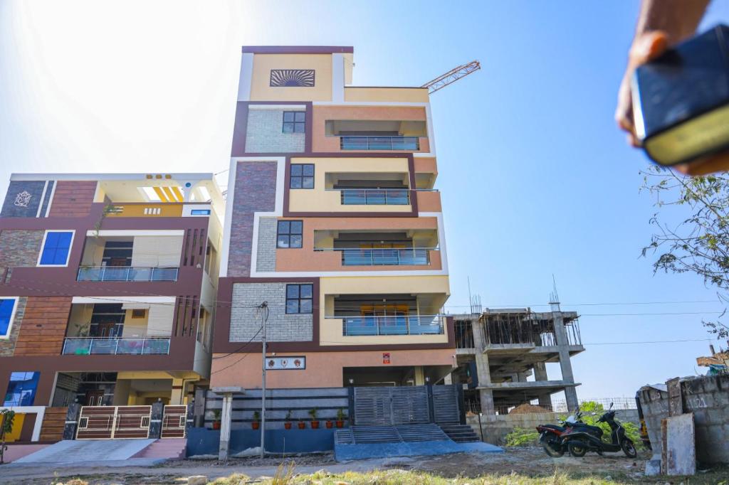 un edificio de apartamentos alto con una motocicleta estacionada frente a él en SKV Residency, en Tirupati