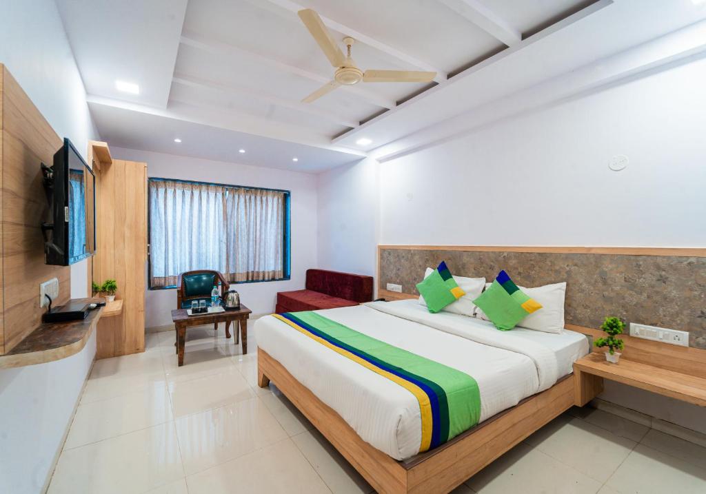 a hotel room with a bed and a tv at Treebo Trend Bright Plaza in Mahabaleshwar