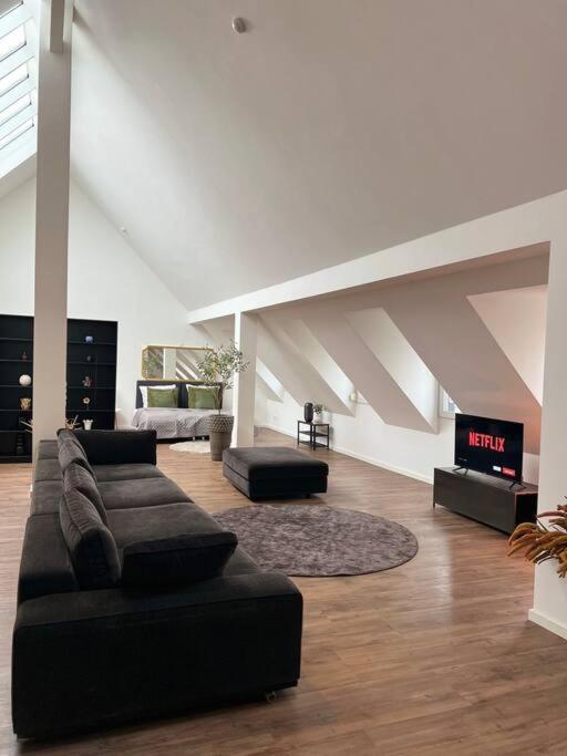 a living room with a couch and a tv at Urban Charm Design Loft in Koblenz