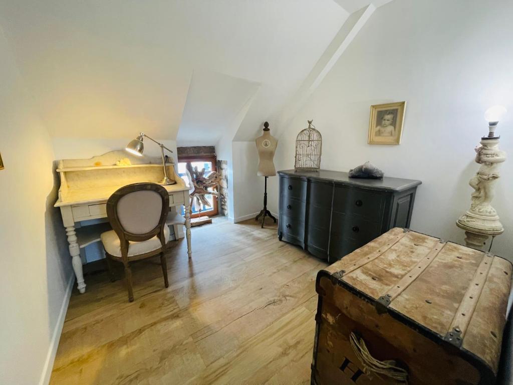 Cette chambre mansardée comprend un bureau et une table. dans l'établissement Le Clos des Anges, adorable Penty bord de mer, à Séné