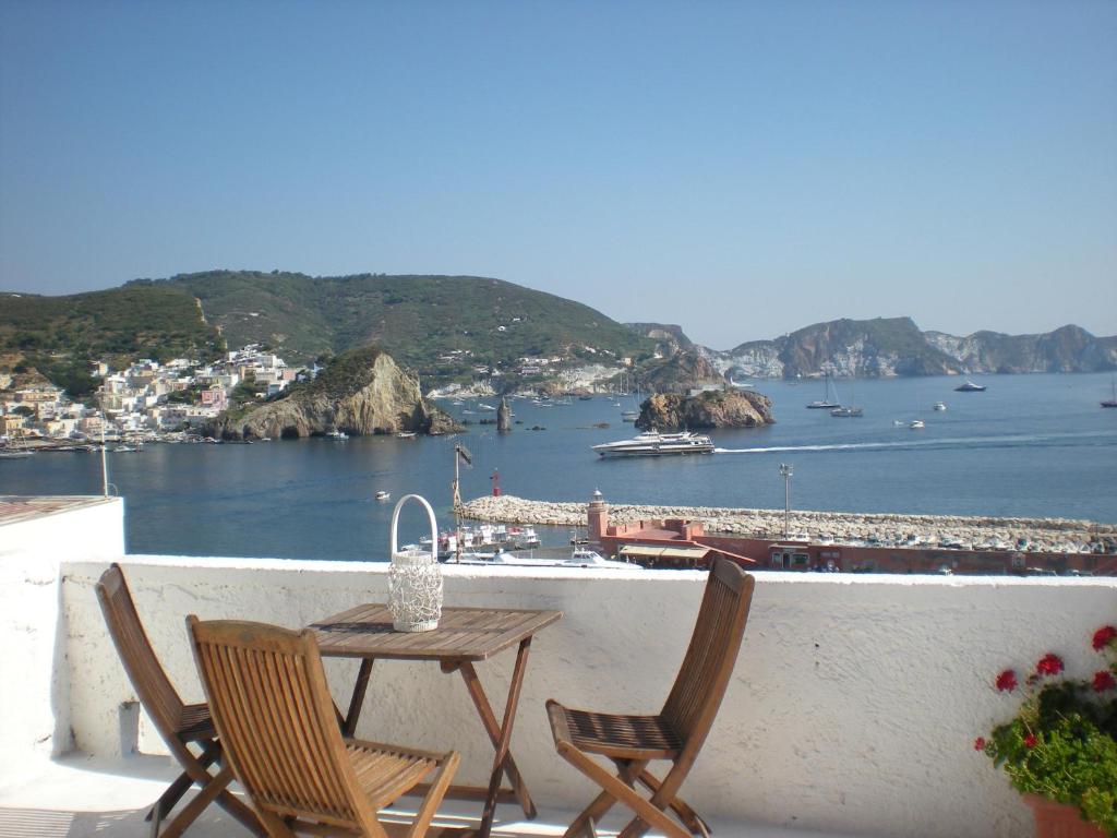einen Tisch und Stühle auf einem Balkon mit Blick auf die Bucht in der Unterkunft Residenze Azzurra in Ponza